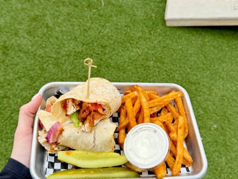 A grilled chicken wrap with seasoned fries and pickles at Trussville Social